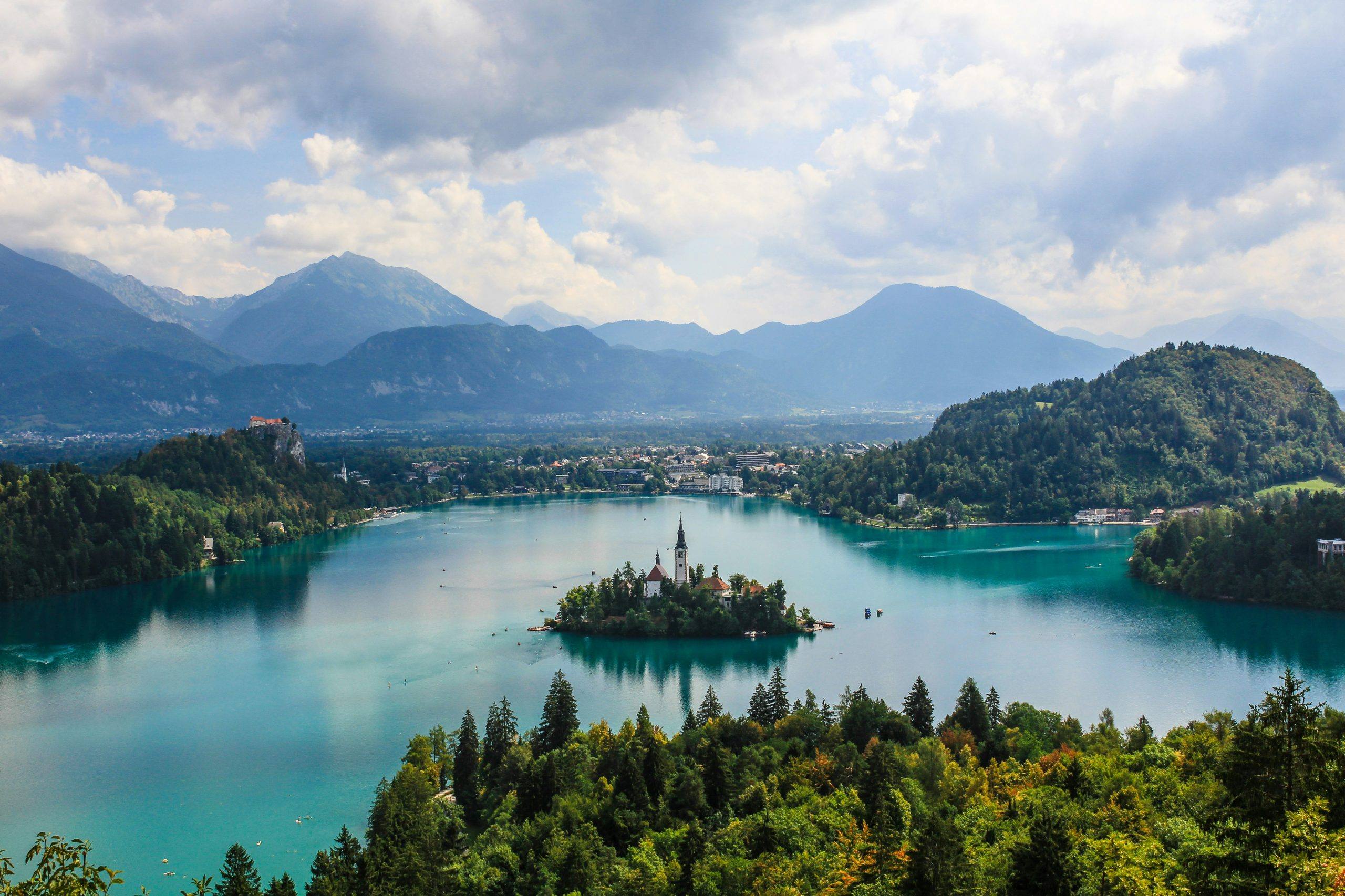 island in middle of lake with a church. Mountains in the background